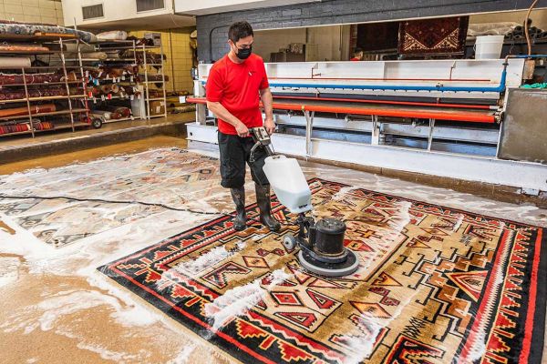 Worker cleaning rug