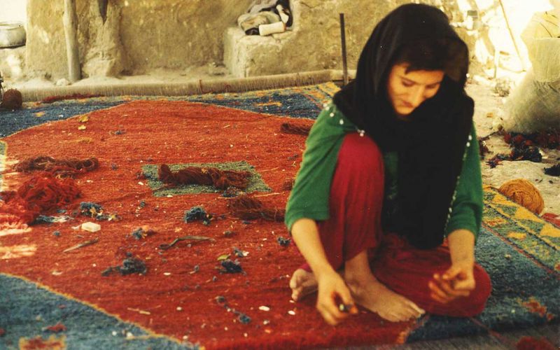 Iranian woman weaving Gabbeh rug